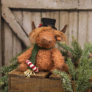 Sitting Highland Cow with Candy Cane